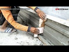 a man is working on the side of a building with wood planks and cement