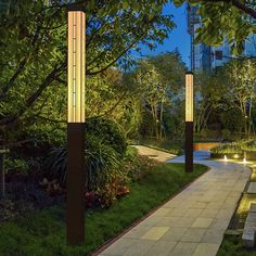 the walkway is lit up at night with lights on it and trees in the background