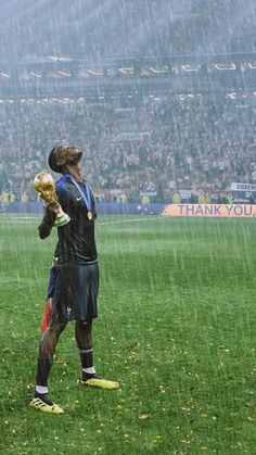 a soccer player holding a ball in the rain