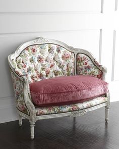 an old style couch sitting on top of a hard wood floor next to a white wall