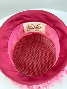 "What a beauty! Tall 1960s pink flowered hat covered by pink netting. Satin brim. Made by Parke Layne. Size 21\". Stands 6\" tall. Very good condition." Retro Pink Wide Brim Hat, Vintage Fitted Pink Hat, Fitted Vintage Pink Hat, Spring Pink Mini Cap Hat, Retro Pink Brimmed Hat, Pink Vintage Wide Brim Hat, Pink Bucket Hat For Kentucky Derby, Pink Fitted Cap Mini Hat, Vintage Pink Cloche Hat