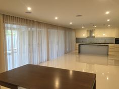 an empty living room and kitchen with sliding glass doors