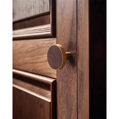 a close up of a door handle on a wooden cabinet