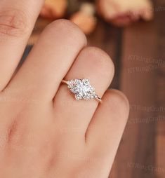 a woman's hand with a three stone diamond ring on her finger, showing the side view