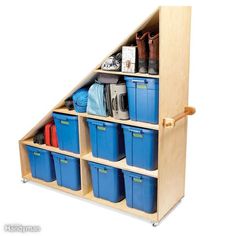 a wooden shelf filled with lots of blue plastic containers and bins next to each other