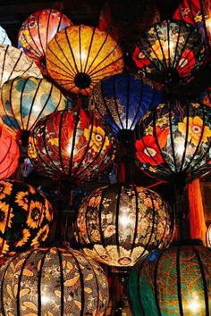 many colorful lanterns are hanging from the ceiling