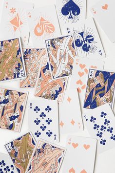 many playing cards are laying on top of each other with blue and orange designs around them