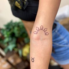 a woman's arm with a tattoo on it that has the sun and zodiac symbols