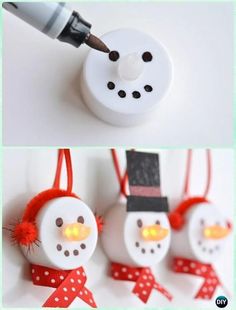 three snowmen are hanging from red string and one is being painted white with black dots