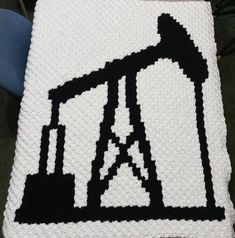 a crocheted blanket with an image of a tractor on it and the letter a written in black