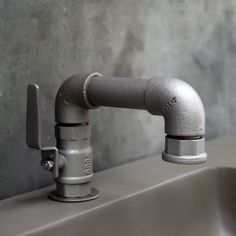 a metal faucet on top of a sink in a bathroom