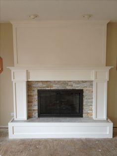 an empty living room with a fireplace in the middle and no one around it on the floor