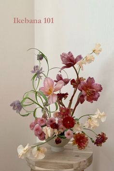 an arrangement of flowers in a vase on a table with the words ikebana 101 above it