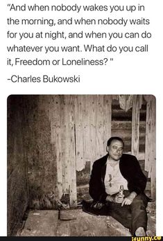 a man sitting on top of a wooden floor next to a wall with words above it