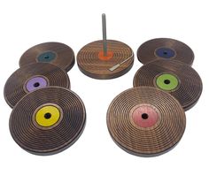 six wooden coasters with different colored circles on them and an umbrella in the middle