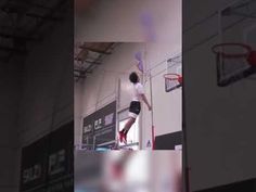 the man is jumping up to dunk the basketball in the air with his hands