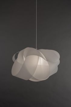 a white light hanging from a ceiling fixture in a room with dark walls and flooring