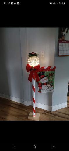 a candy cane is wrapped in red and white paper with a bow on it's end