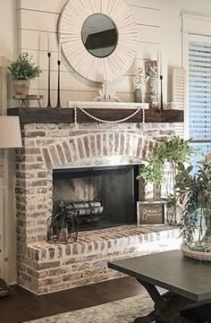 a living room filled with furniture and a fire place in front of a brick fireplace