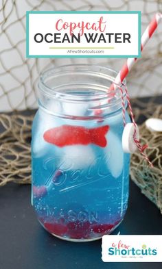 a mason jar filled with blue liquid and red fish