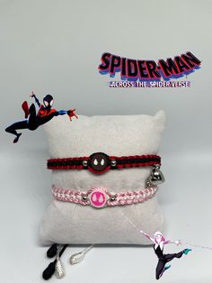 the spiderman bracelets are on display in front of a pillow and some toys