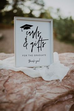 a sign that reads graduation and gifts for the graduate on top of a rock with tissue