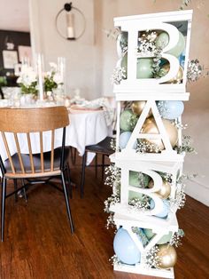 a wooden table topped with lots of white and blue decorations next to a dining room table