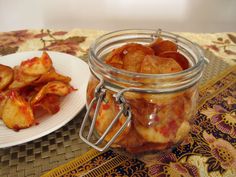 a jar filled with food sitting on top of a table next to a white plate