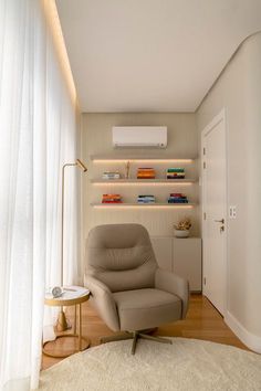 a living room with a chair, table and bookshelf on the wall behind it