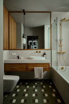 a bathroom with green and white checkered flooring next to a bathtub, toilet and sink