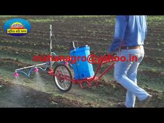 a man is spraying the ground with a sprayer on his farm tractor while standing next to it