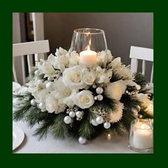 a centerpiece with white flowers and greenery