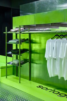 a green room with some white shirts hanging on the rack