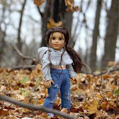 a doll is standing in the leaves with her head turned to look like she has fallen