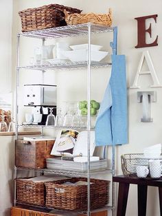 a metal shelving unit with baskets on the bottom shelf and other items in front of it