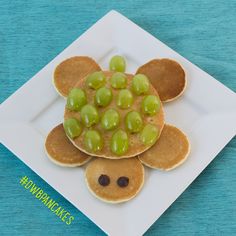 a plate topped with pancakes covered in grapes and a tortilla shell shaped like a turtle