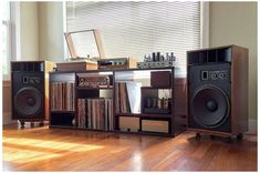 there are speakers and other electronic equipment in the room with wood flooring on the wooden floor