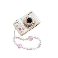 a white camera with pink flowers on it and a lanyard attached to the strap