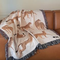 a blanket with giraffes on it sitting on a couch