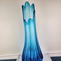 a blue vase sitting on top of a white table