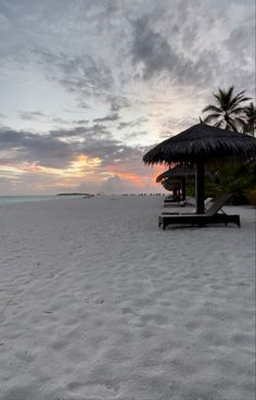 the sun is setting on an empty beach