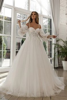 a woman in a white wedding dress posing for the camera