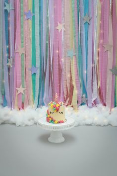 a birthday cake sitting on top of a white plate next to streamers and stars