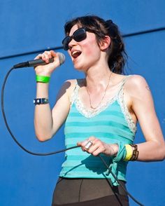 a woman singing into a microphone on stage