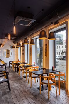 a restaurant with wooden tables and yellow chairs