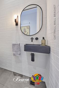 a bathroom with a sink, mirror and towel rack on the wall next to it