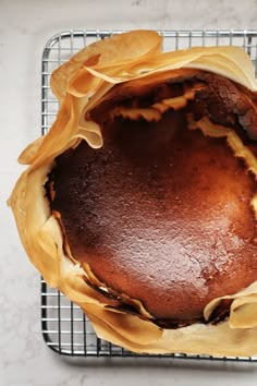 a cake sitting on top of a cooling rack next to a wire rack with some food in it