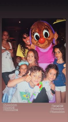 a group of children posing for a photo in front of a large stuffed animal mascot