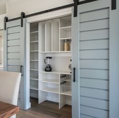 an open sliding door in a kitchen with white cabinets and drawers on either side of the room