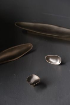 three silver spoons on a black surface